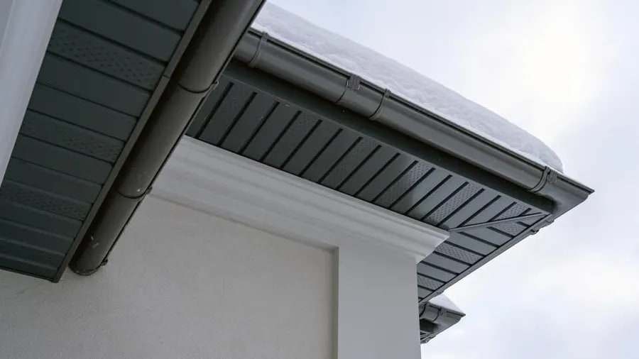 Anthracite grey vented soffits with matching gutters and downpipes on a modern rendered house