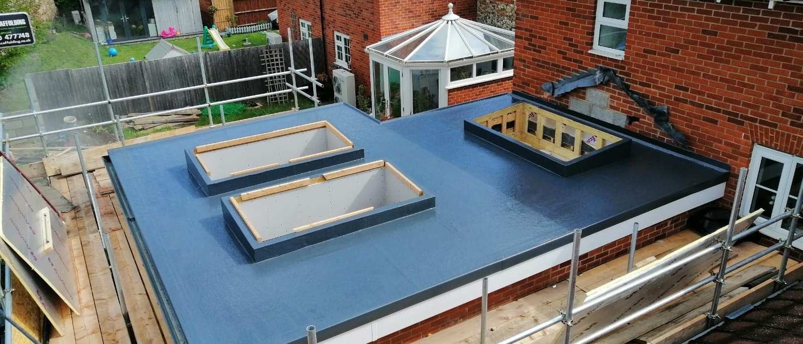 A flat roof covering laid over new timber decking on a residential house extension