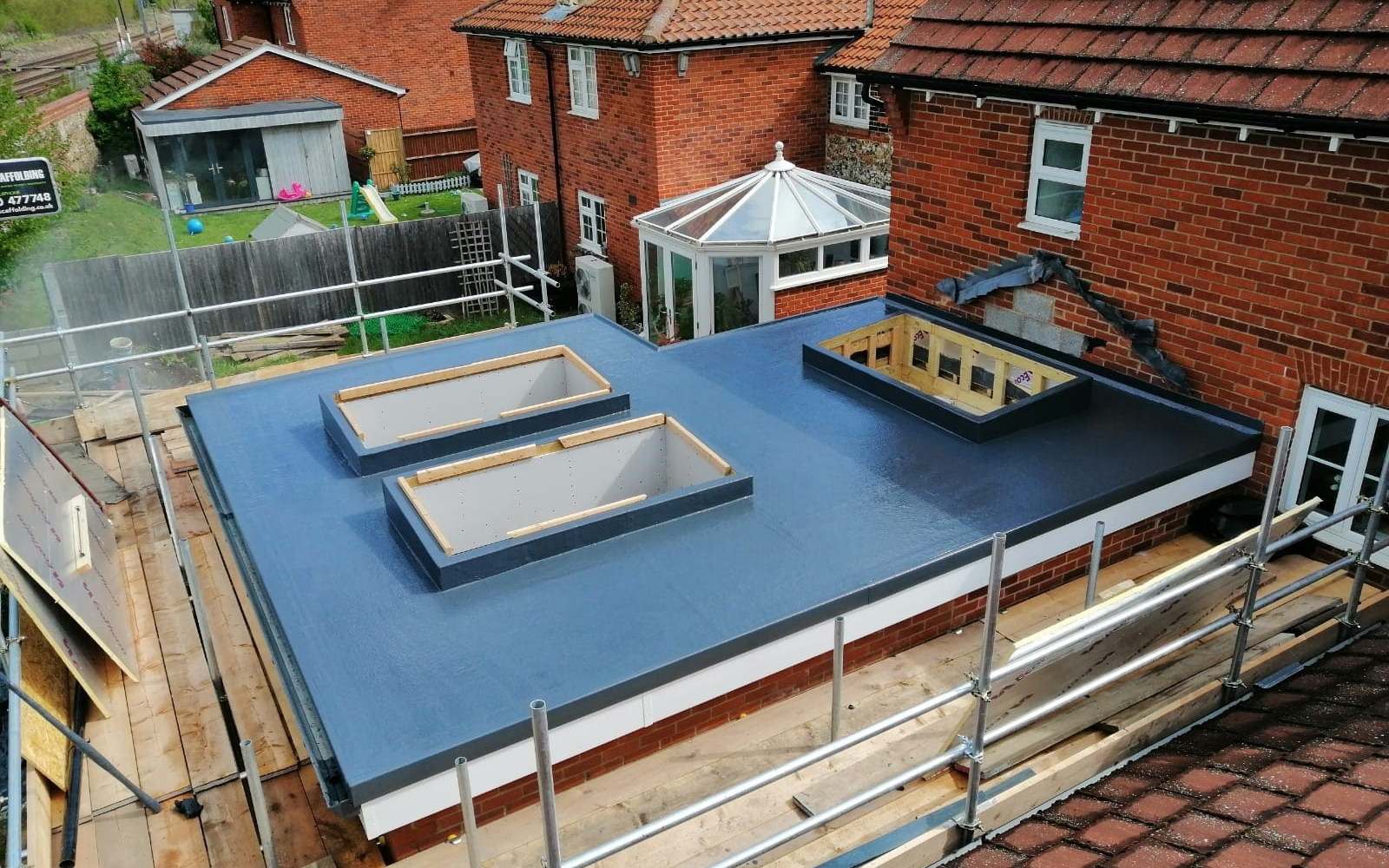 A flat roof covering laid over new timber decking on a residential house extension